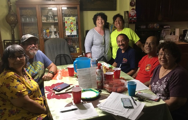 Residents meeting around a table at a community gathering