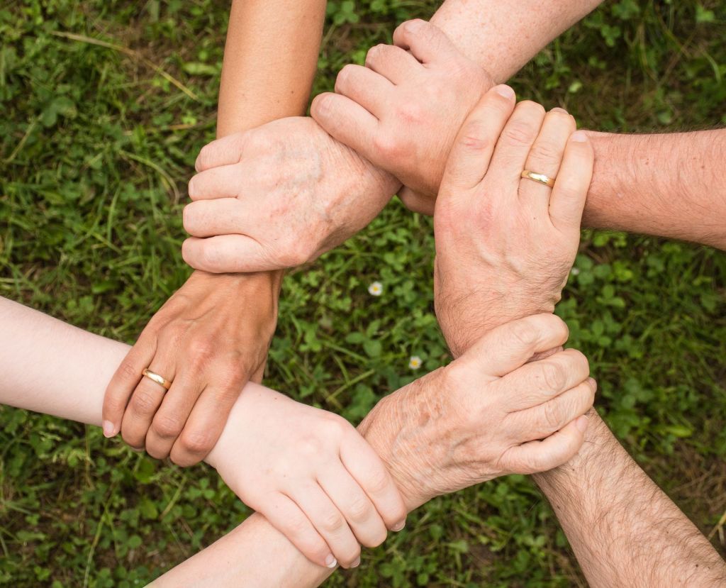 Hands of different skin tones linked together in a circle