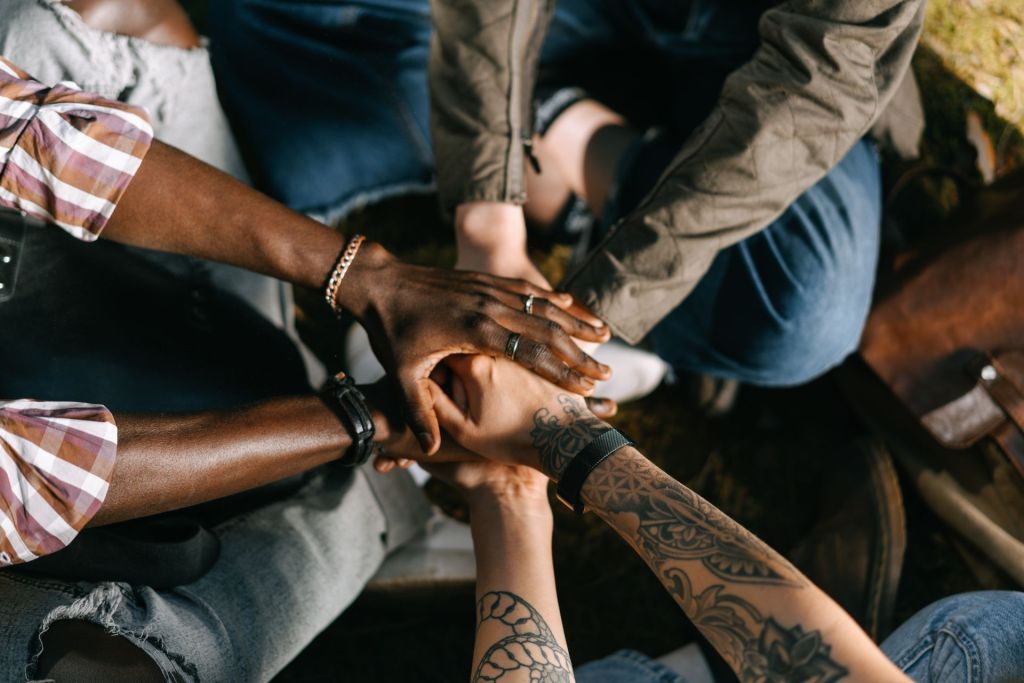 Hands of people of different races stacked together in unity
